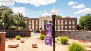 The Sandefer Building stands behind the Alumni Wall on campus at Hardin-Simmons University.